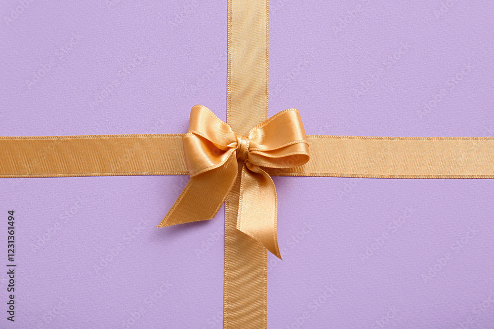 Golden ribbons with bow on lilac background Golden ribbons with bow on lilac background
