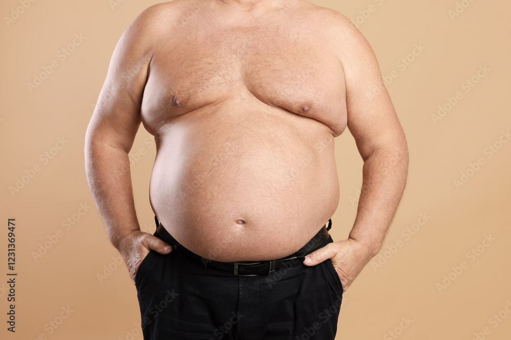 Naklejka premium Man with excessive belly fat on beige background, closeup. Overweight problem