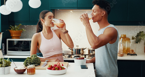 Fototapeta Couple, drinking and juice for breakfast at house of healthy meal, nutrition diet and bonding together