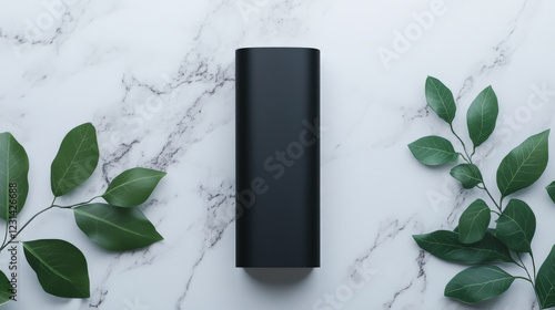 Sleek black power bank rests on a marble surface, adorned with lush green leaves. A minimalist, eco-friendly aesthetic.