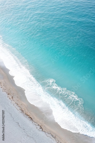 Turquoise waves gently kiss sandy shore, creating serene coastal photo