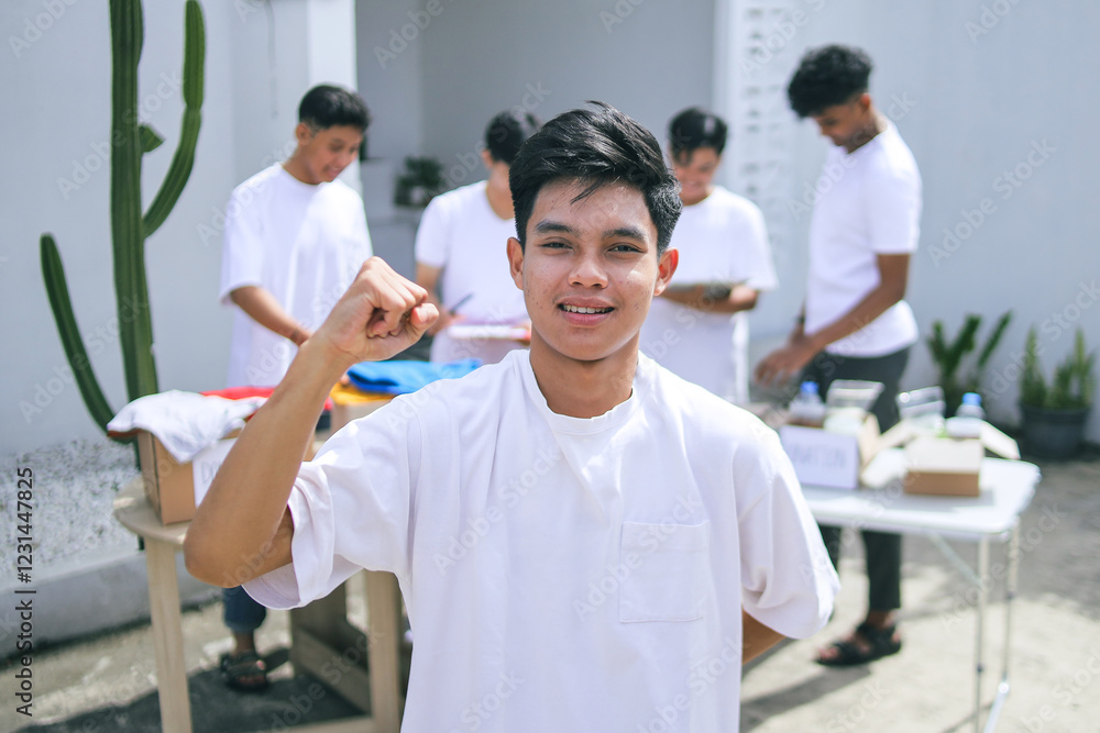 Fototapeta premium Young Teenage Volunteer Raising Fist Giving Motivation For Charity Movement 