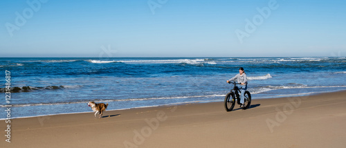 Generated imaBeautiful young girl riding an electric fat bike with her dog.ge photo