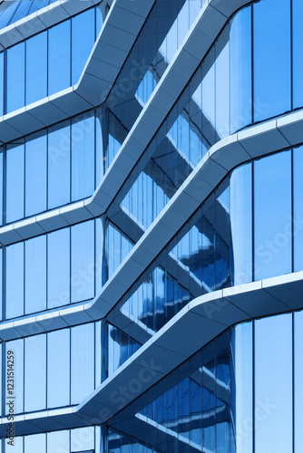 Photography A close-up view of a modern glass building with a striking geometric design
