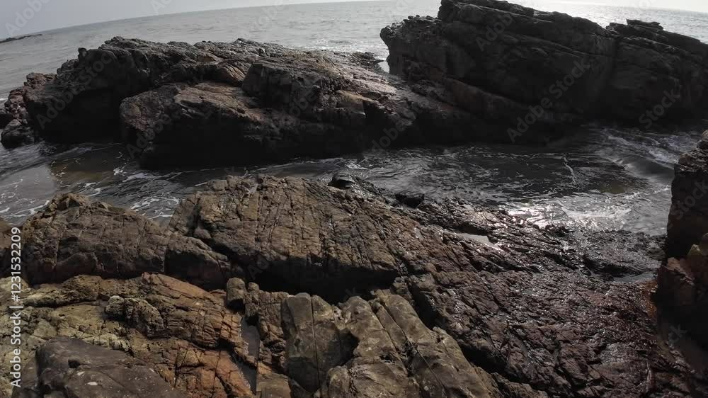 Ocean Waves Crashing Among Small Black Rocks At Beach Ocean Waves Crashing Among Small Black Rocks At Beach