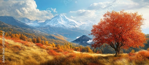 Vibrant autumn landscape with orange trees in foreground, majestic snow-capped mountains and hints of volcanic peaks under a bright blue sky.