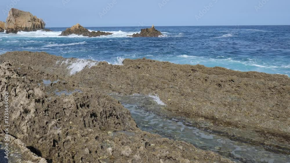 Visitors explore stunning natural pools at Arnía Beach, enjoying the clear waters and rocky surroundings on a sunny day. The beautiful coastline invites relaxation and adventure. Visitors explore stunning natural pools at Arnía Beach, enjoying the clear waters and rocky surroundings on a sunny day. The beautiful coastline invites relaxation and adventure.