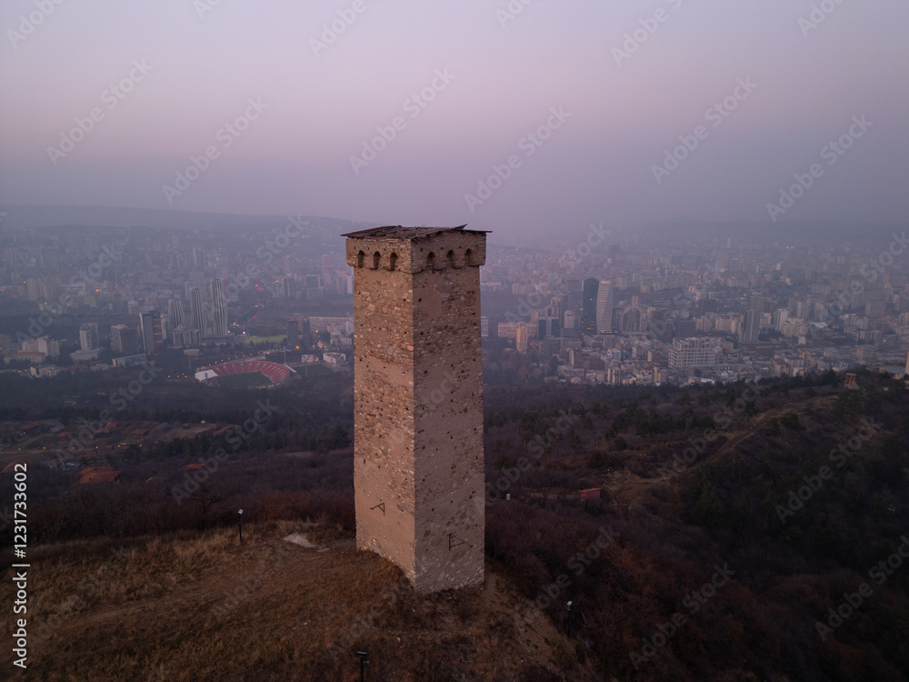 Ancient tower opposite city skyscrapers in Georgia - aerial view Ancient tower opposite city skyscrapers in Georgia - aerial view