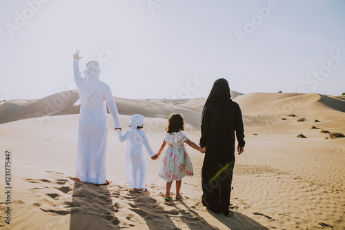 Happy family from Uae spending time in the Dubai desert making a picnic. Kid with the uae flag. photo