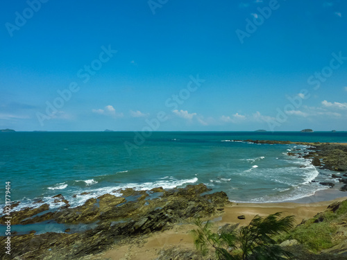 Obraz na płótnie Rugged rocky coastline meets turquoise waters at Emu Park Beach in Queensland, Australia. Dramatic cliffs and volcanic rocks frame secluded sandy cove. Distant islands dotting pristine Coral Sea w salonie