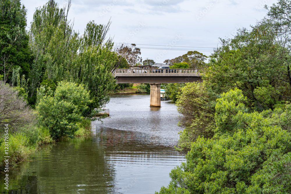 The concrete bridge on Princes Highway stretches across the Mitchell River in Bairnsdale, Victoria. A peaceful rural Australian waterway in regional Australia. The concrete bridge on Princes Highway stretches across the Mitchell River in Bairnsdale, Victoria. A peaceful rural Australian waterway in regional Australia.