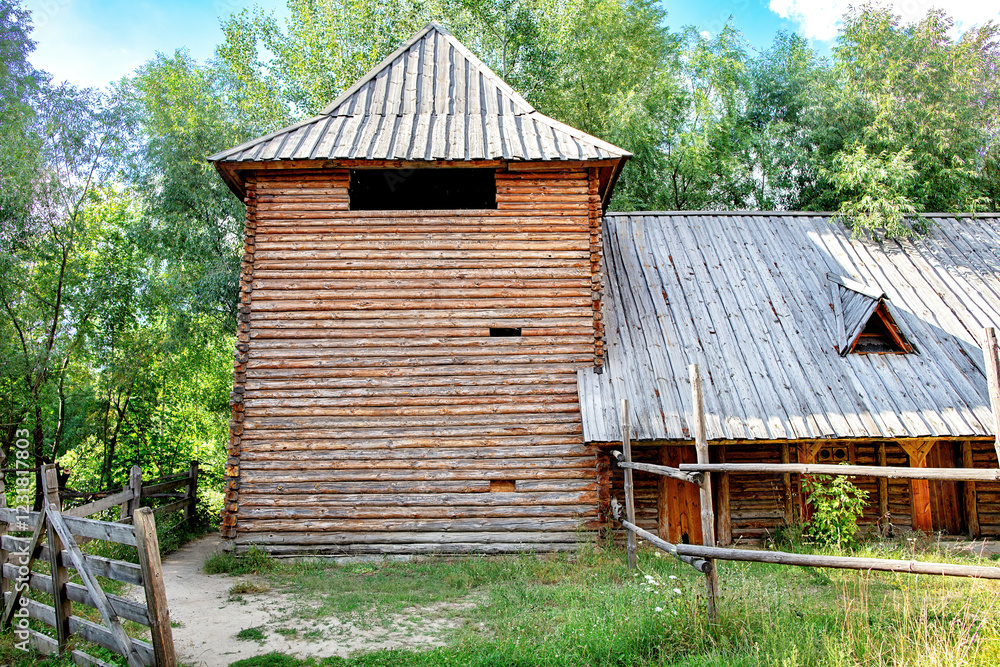 Rustic watchtower wooden structure stands proudly amid lush greenery under a clear sky.