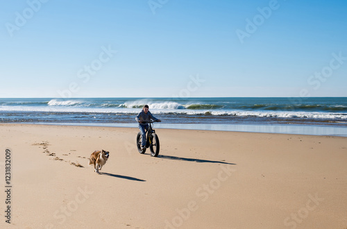 Beautiful young girl riding an electric fat bike with her dog. photo