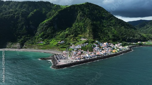 Ribeira Quente village with breakwater on picturesque coastline, aerial arc view photo