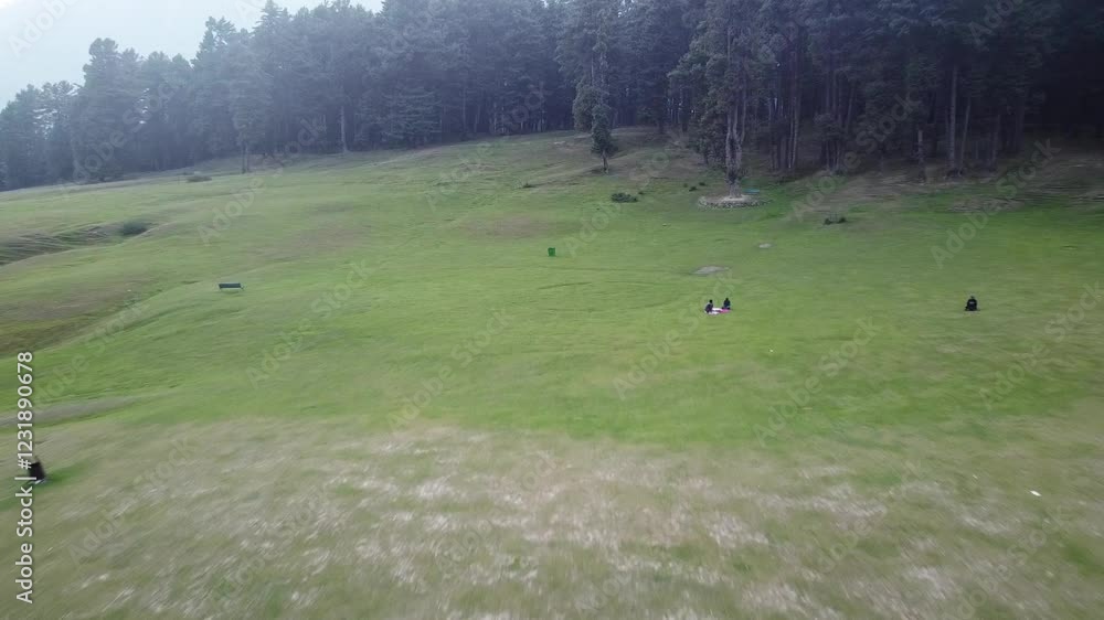 Drone View of Lush green valley full of trees with mountains in the background, tourists enjoy amidst a beautiful landscape Drone View of Lush green valley full of trees with mountains in the background, tourists enjoy amidst a beautiful landscape