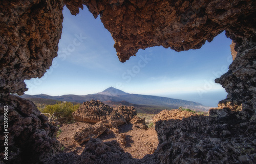 Vue impressionnante du volcan Teide à Tenerife, capturée à travers une formation rocheuse volcanique naturelle. Ce paysage emblématique des îles Canaries met en avant la beauté brute du parc national 