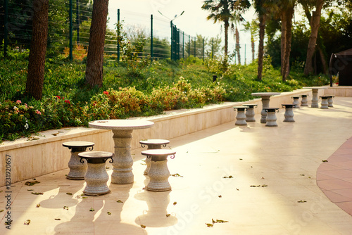 Stone Tables and Stools in a Sunny Outdoor Park Setting.. photo