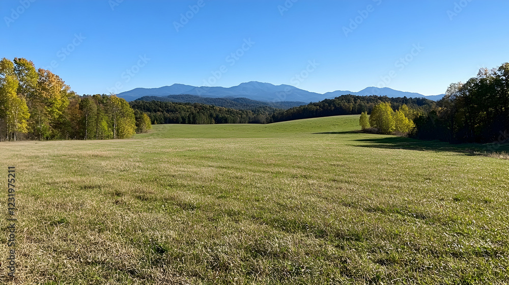 Obraz premium Autumnal field, mountain vista, clear sky; idyllic rural landscape for travel brochures