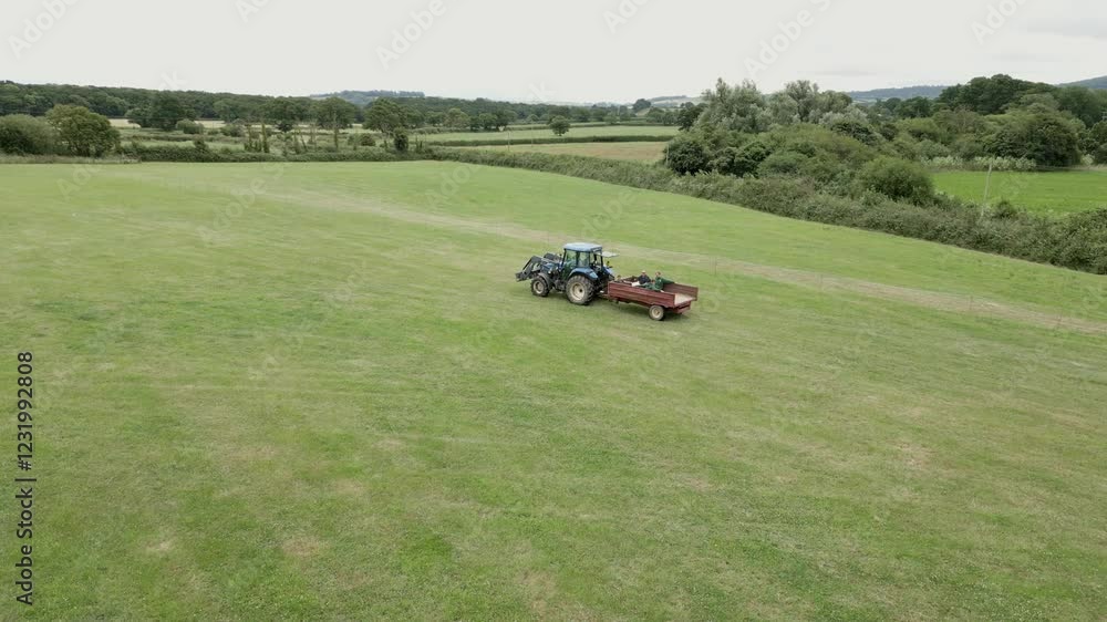 Aerial View of Tractor and Trailer with People Driving Through UK Countryside Aerial View of Tractor and Trailer with People Driving Through UK Countryside