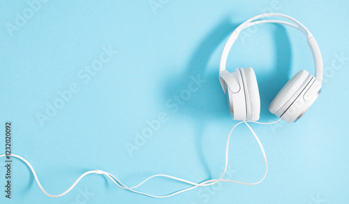 Large white headphones on a light blue background. photo