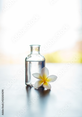 Wellness, mockup and essential oil with flower on table for skin health, healthy body and aromatherapy massage. Interior space, cosmetics and healing product for skincare, antioxidants and anti aging