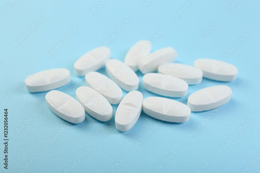 Many antibiotic pills on light blue background, closeup Many antibiotic pills on light blue background, closeup