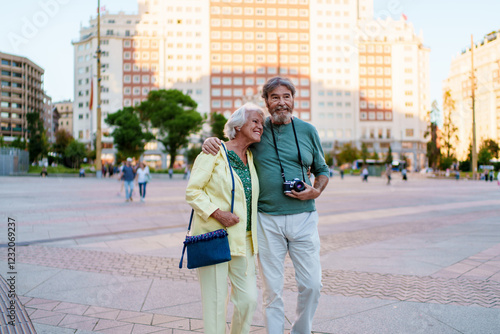 Happy senior couple walking in plaza de espana, madrid, enjoying vacation photo