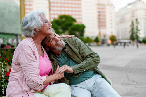 Happy senior couple holding hands and enjoying retirement in the city photo