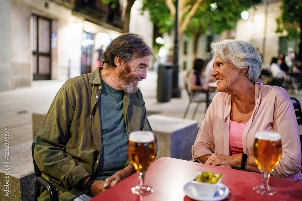Happy senior couple enjoying beer and tapas at outdoor cafe Happy senior couple enjoying beer and tapas at outdoor cafe