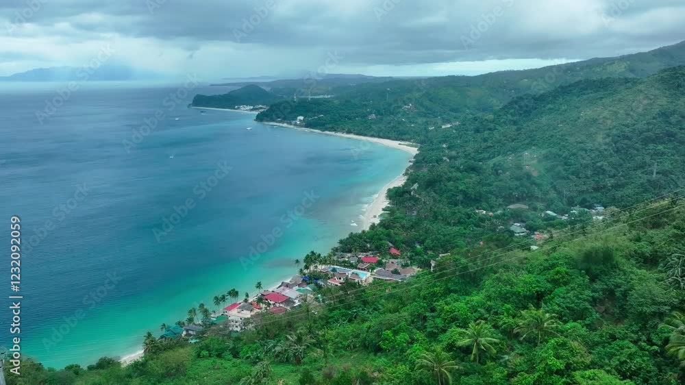 Aerial view of Aninuan beach with Puerto Galera Town, Philippines. Cloudy day with green mountain landscape. Wide shot. Aerial view of Aninuan beach with Puerto Galera Town, Philippines. Cloudy day with green mountain landscape. Wide shot.