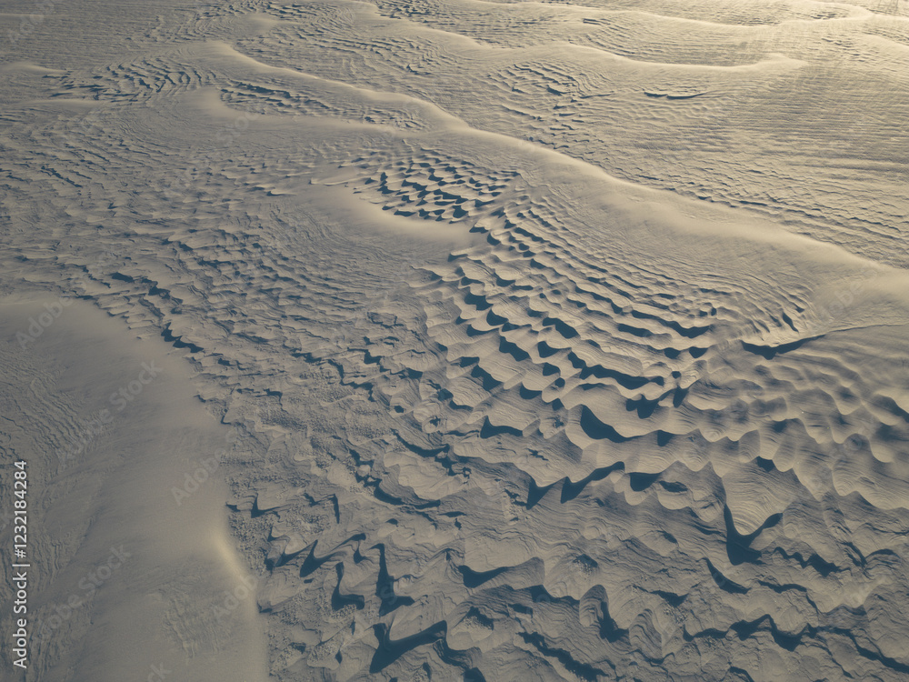 Abstract winter landscape from a bird's-eye view: endless expanses of a snow-covered field under a gray sky, covered with a light haze, creating a sense of solitude and peace. Abstract winter landscape from a bird's-eye view: endless expanses of a snow-covered field under a gray sky, covered with a light haze, creating a sense of solitude and peace.