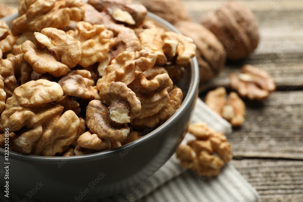 Fresh walnuts in bowl on wooden table, closeup Fresh walnuts in bowl on wooden table, closeup