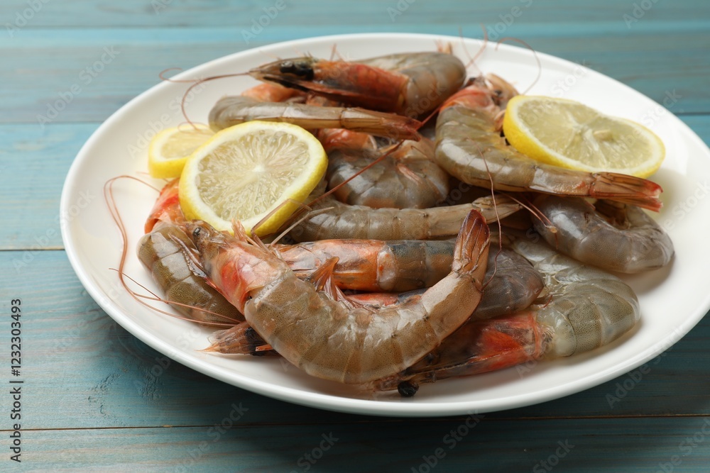 Fresh raw shrimps with lemon on light blue wooden table, closeup Fresh raw shrimps with lemon on light blue wooden table, closeup