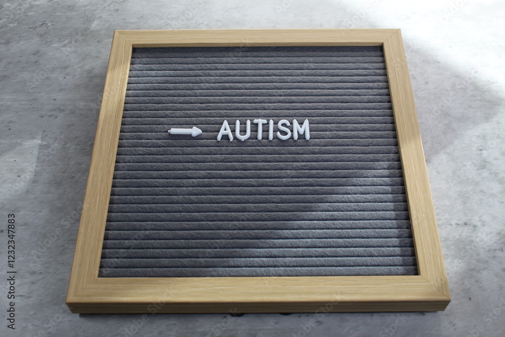 Autism written on a letter board with white tiles. Sunlight coming across Autism written on a letter board with white tiles. Sunlight coming across