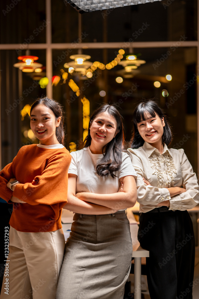 Fototapeta premium Three women are standing together, smiling and posing for a photo