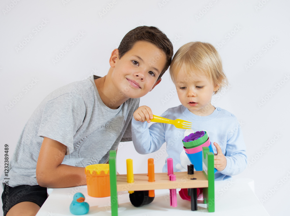 Child boy playing with little brother over white background. Child boy playing with little brother over white background.
