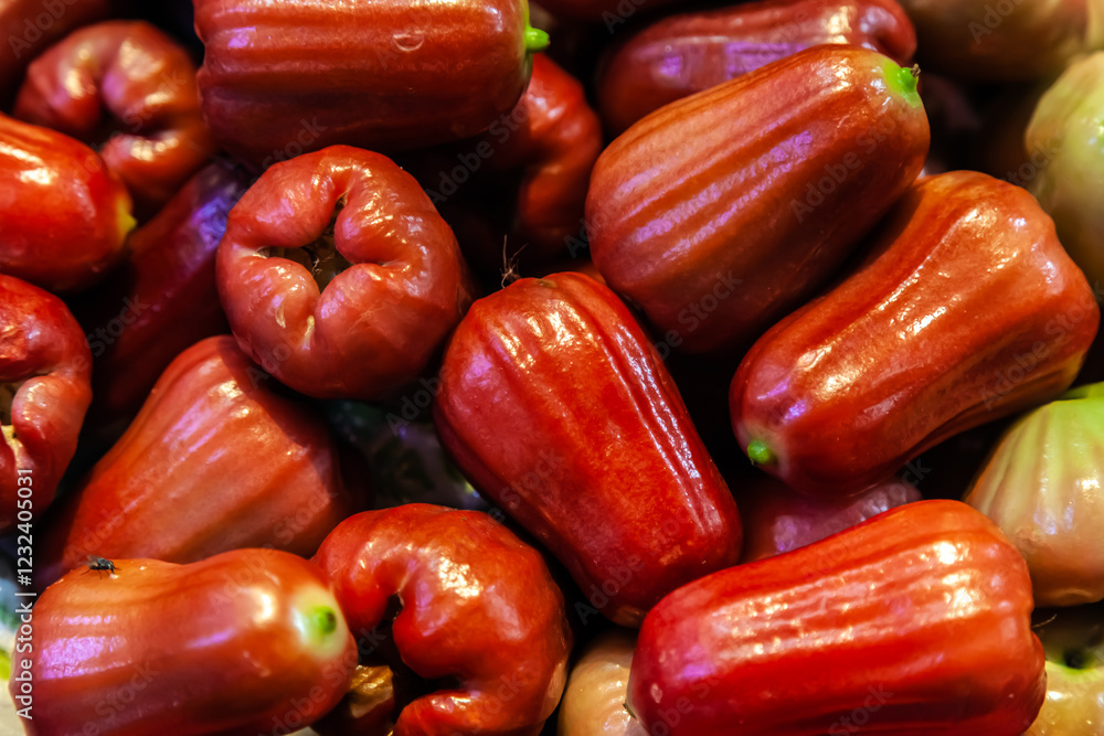 A pile of organic fresh rose apple or jambu fruits sold at a market A pile of organic fresh rose apple or jambu fruits sold at a market