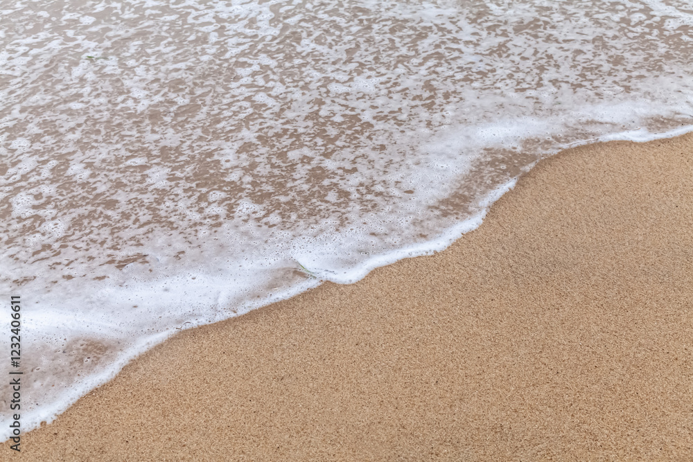 Texture of a wave from the sea with a little white foam slowly advancing a sandy beach Texture of a wave from the sea with a little white foam slowly advancing a sandy beach