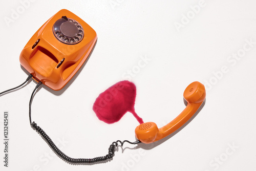 Orange rotary phone with disconnected receiver lies next to spilled red liquid, show chaotic night filled with drunk conversations and unanswered calls. Concept of alcohol, hangover, afterparty mood. photo