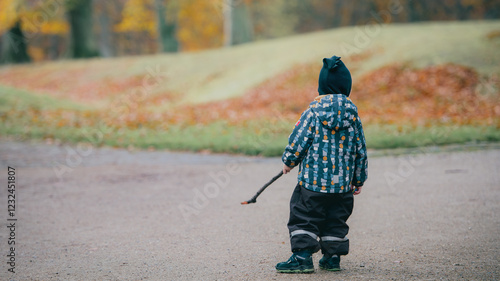 Child in Warm Clothes Exploring Outdoors in Autumn Season with Nature Around