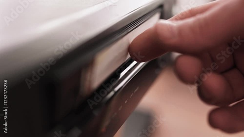 Close up of a hand holding a videotape. Retro vhs cassete in a player.