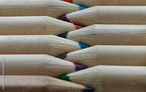 Obraz na płótnie Close-up of Two groups brown crayons are sharp tips and facing collide in a neat row. Wooden pencils to each other arranged in a symmetrical radial, The arrangement of the colors pencils creates. w salonie