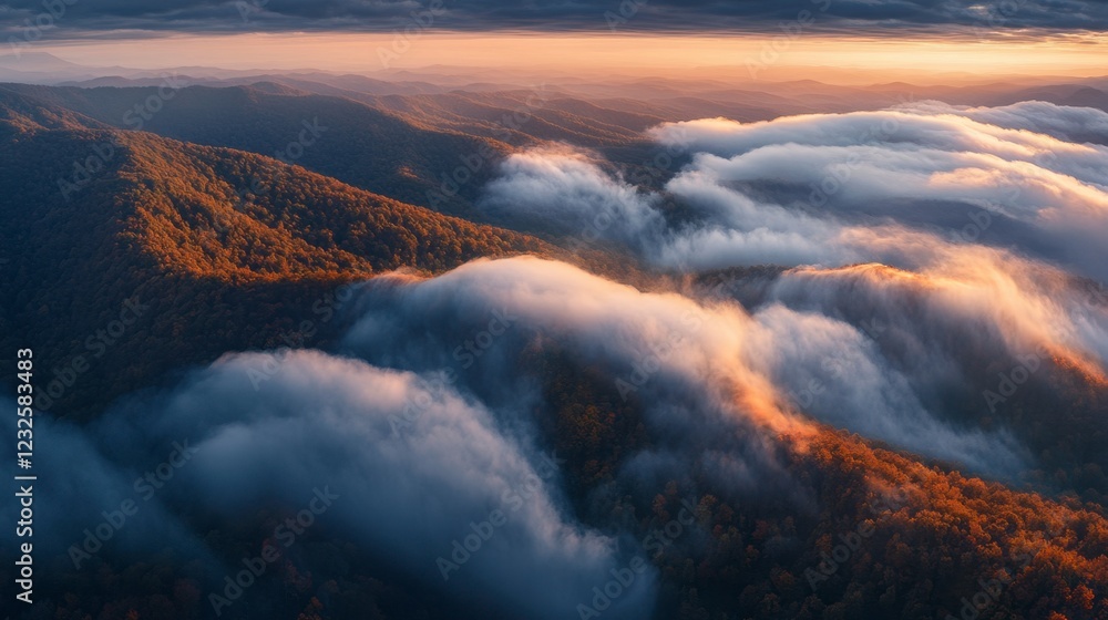 Fototapeta premium Dramatic aerial capture of thick clouds rolling over a mountain range