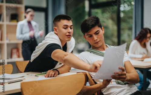 Foto Two male students collaborate on a document during a classroom session