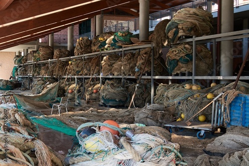 A portside fishing net repair area filled with commercial fishing gear. Shelves hold layers of nets, ropes, and floats, vital for the fishing trade. photo