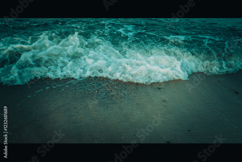 Fototapeta Naklejka Na Ścianę i Meble -  Calm beach on the Baltic Sea in the warm light of sunset. Gentle waves, sandy coastline and subtle atmosphere of relaxation. Perfect image for themes related to nature, travel, and holidays.