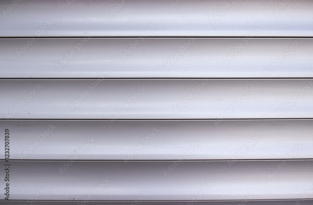 Fototapeta premium Photo of horizontal aluminum slats of a garage door. Horizontal lines, aluminum slats, background, texture. Garage door, detail.