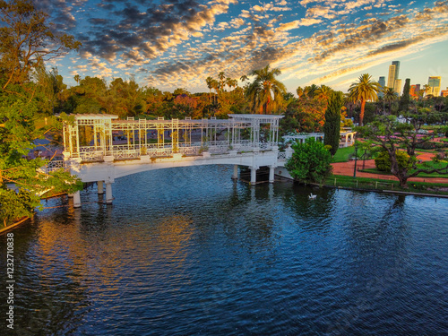Photograph of the Greek Bridge in Palermo's Rose Garden, Buenos Aires, illuminated by golden sunset rays during the golden hour, with a bucolic cloudy sky and no people.
