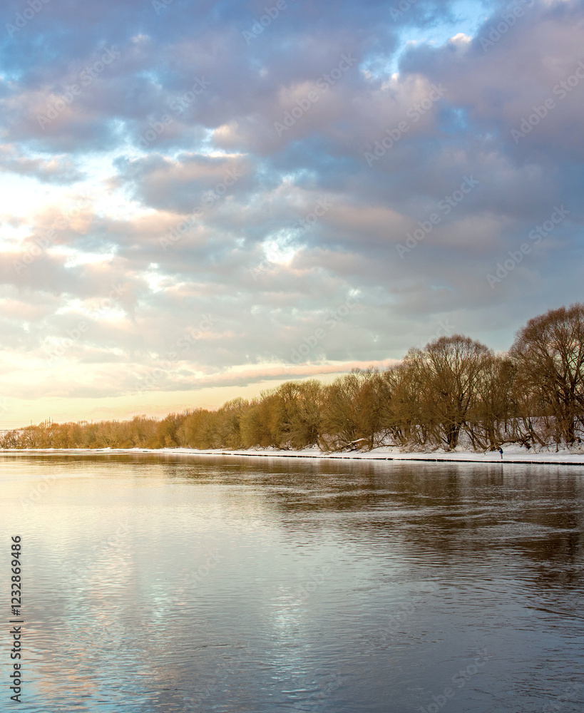 Calm lake with snow on the trees and a cloudy sky Calm lake with snow on the trees and a cloudy sky