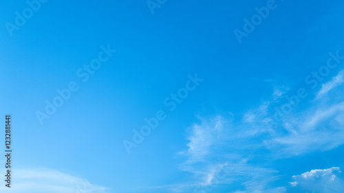 Fototapeta Naklejka Na Ścianę i Meble -  A calm and clear summer sky with gentle, wispy clouds moving across, offering a refreshing backdrop.